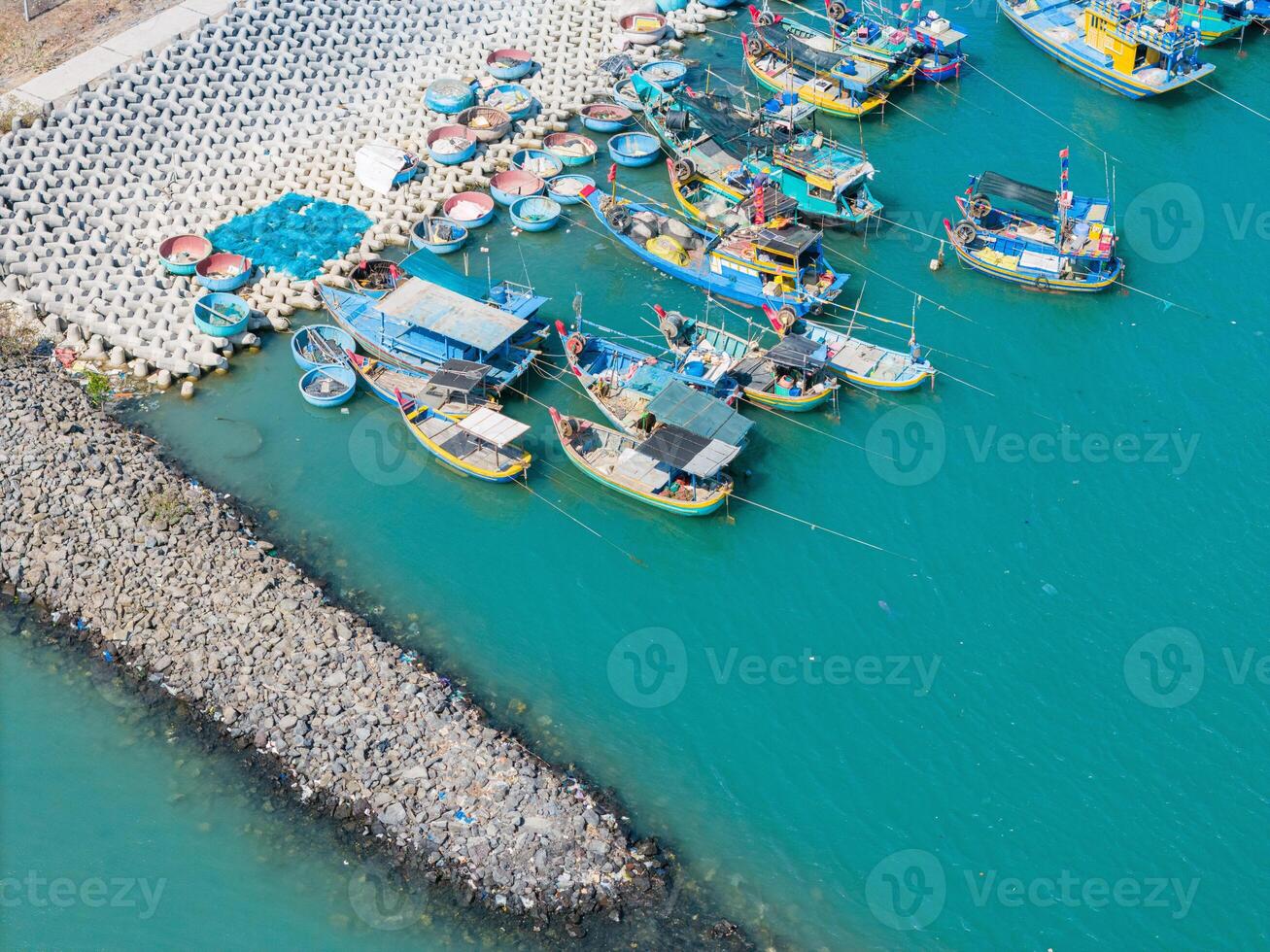 Aerial view of Loc An fishing village, Vung Tau city. A fishing port with tsunami protection concrete blocks. Cityscape and traditional boats in the sea. photo