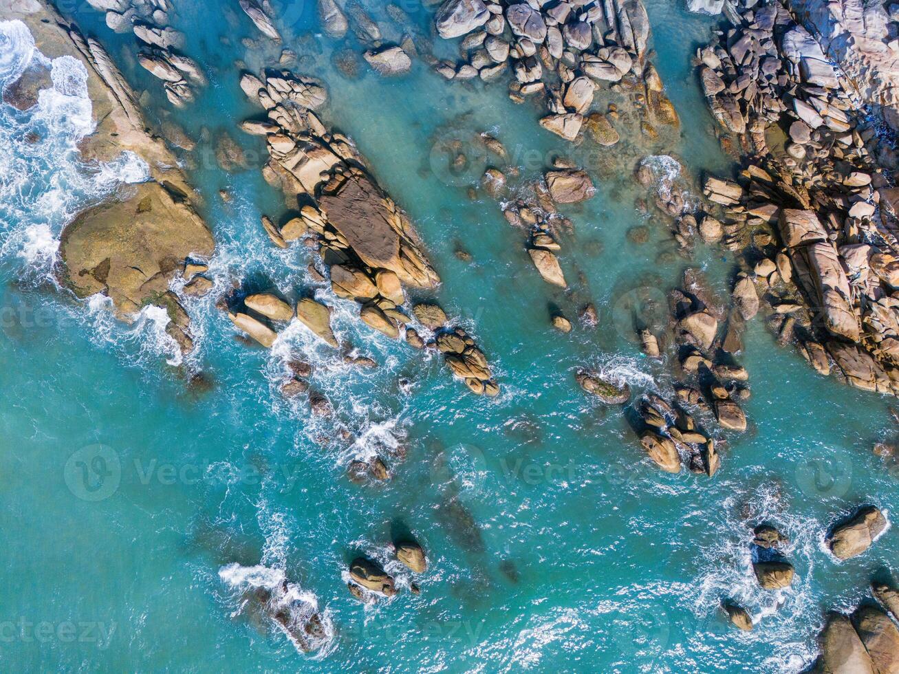 Aerial drone top view of beautiful waves crashing on the rocky island coast, ocean waves and fantastic. Ocean in Vietnam. photo