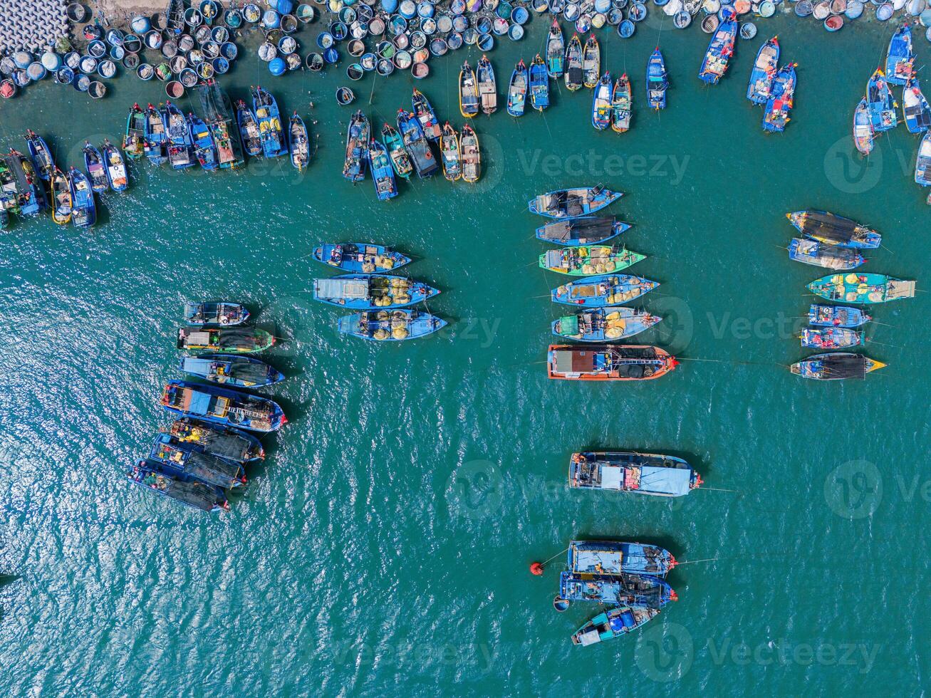 Aerial view of Loc An fishing village, Vung Tau city. A fishing port with tsunami protection concrete blocks. Cityscape and traditional boats in the sea. photo