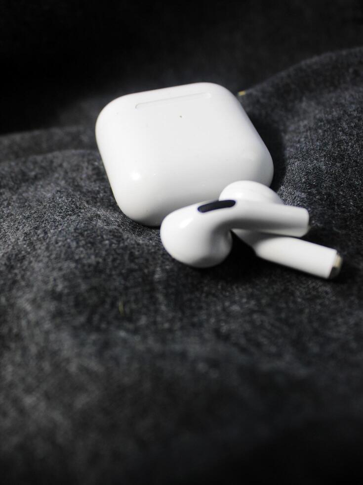 Closeup white TWS true wireless stereo earbuds in case isolated on black background. photo