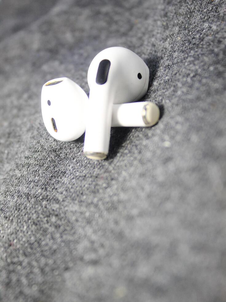 Closeup white TWS true wireless stereo earbuds in case isolated on black background. photo