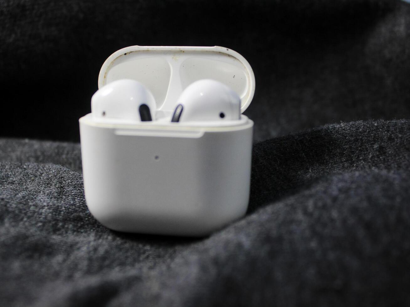 Closeup white TWS true wireless stereo earbuds in case isolated on black background. photo