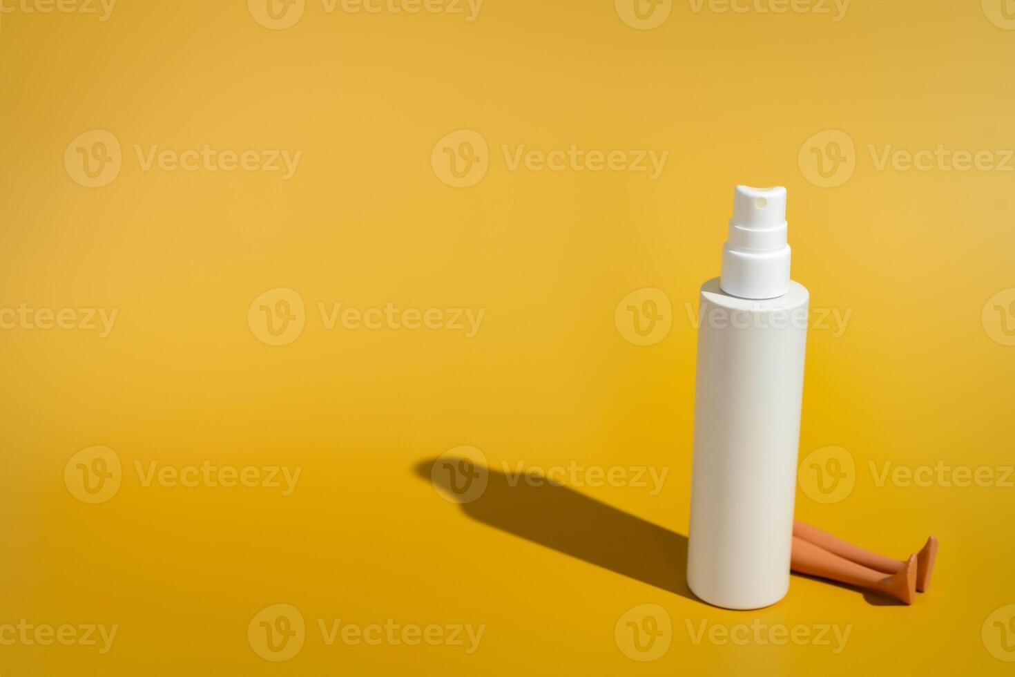 Blank white spray bottle with doll legs in direct sunlight photo