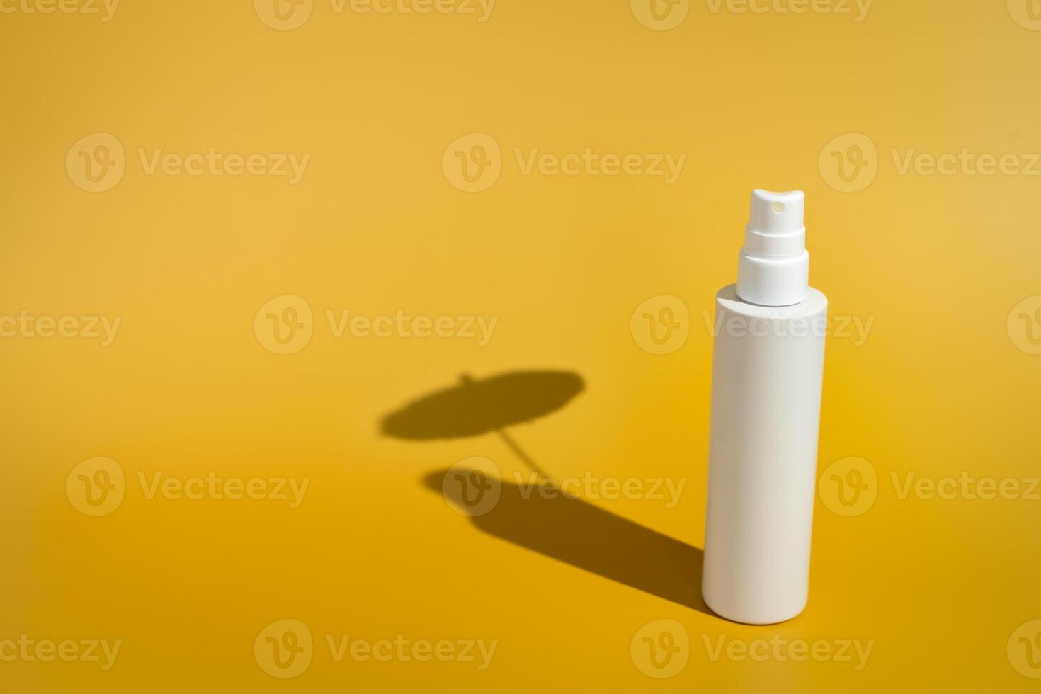 Blank white spray bottle with umbrella shadow in direct sunlight photo