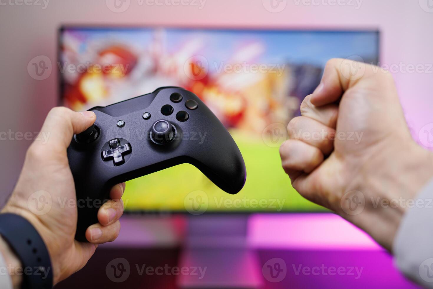 First-person view of the gamepad, which is in the hands, one hand clenched into a fist. game gamepad in hand photo