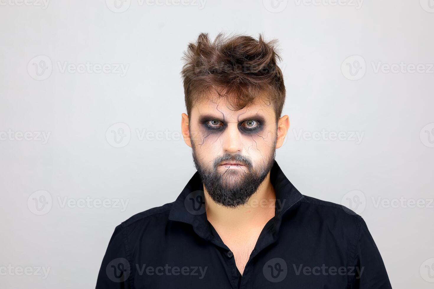 retrato de un hombre en pie en un blanco antecedentes con estilo no-muerto maquillaje para todas santos Víspera de Todos los Santos foto