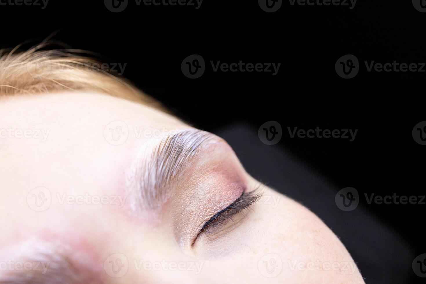 macro photography of an eye with laminating compounds applied to its eyebrows photo