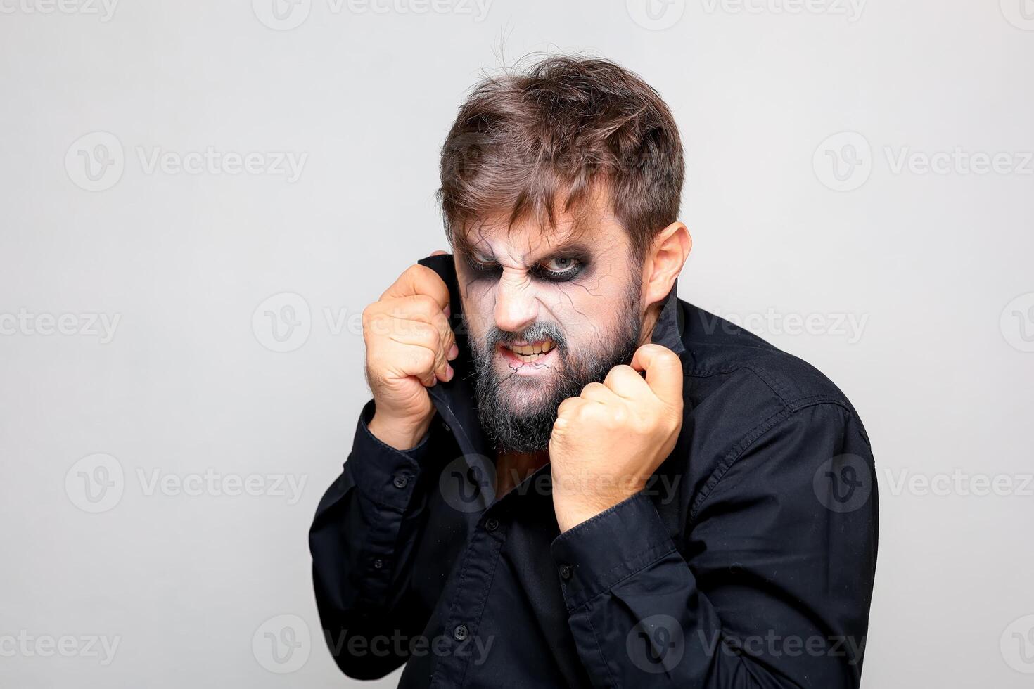 un hombre con un barba y maquillaje para Víspera de Todos los Santos hizo una mueca foto