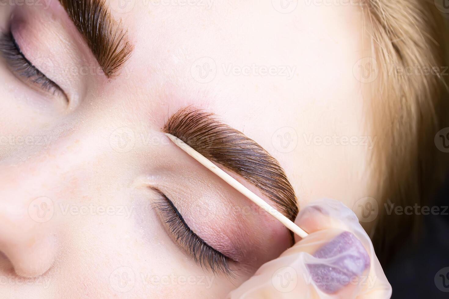 close-up of combed eyebrows with eyebrow paint applied to them photo