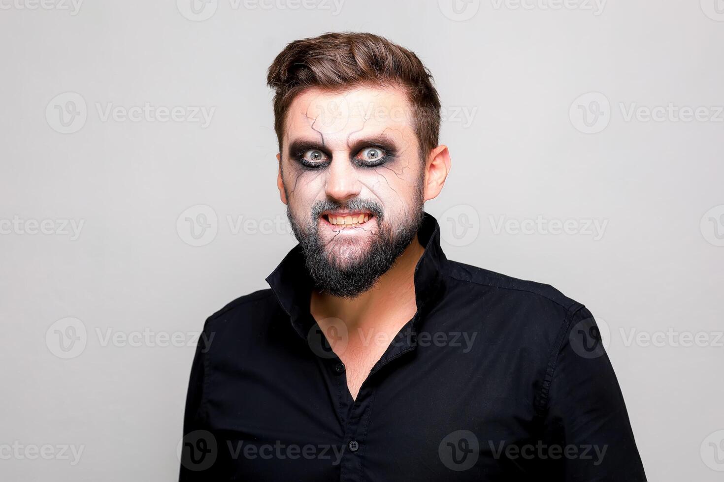 undead makeup for October 31 on a bearded man who shows teeth photo