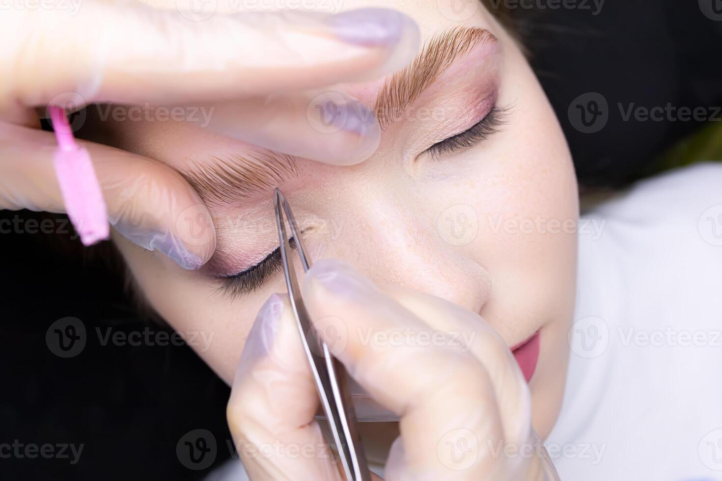 correction and plucking of excess hairs after the eyebrow lamination procedure photo