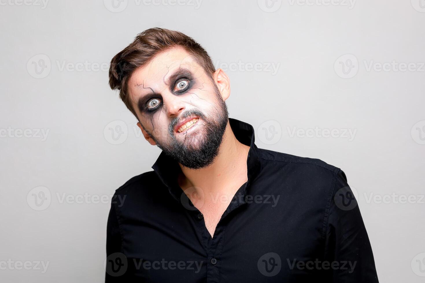 undead makeup for October 31 on a bearded man who shows teeth photo