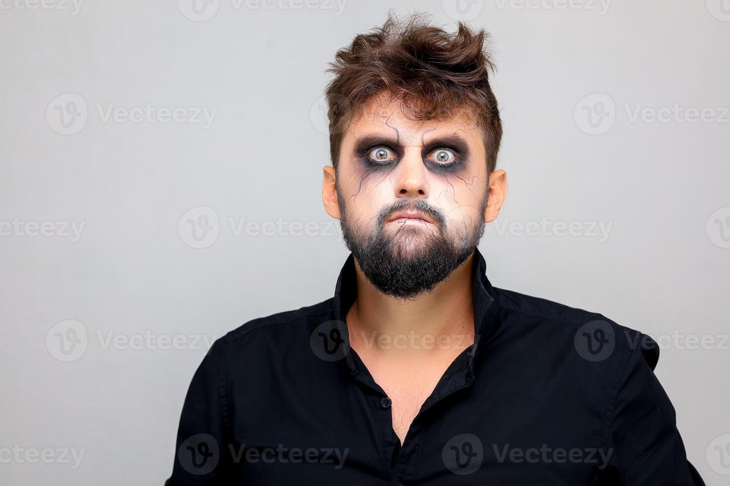 portrait of a man standing on a white background with undead-style makeup for All Saints Halloween photo