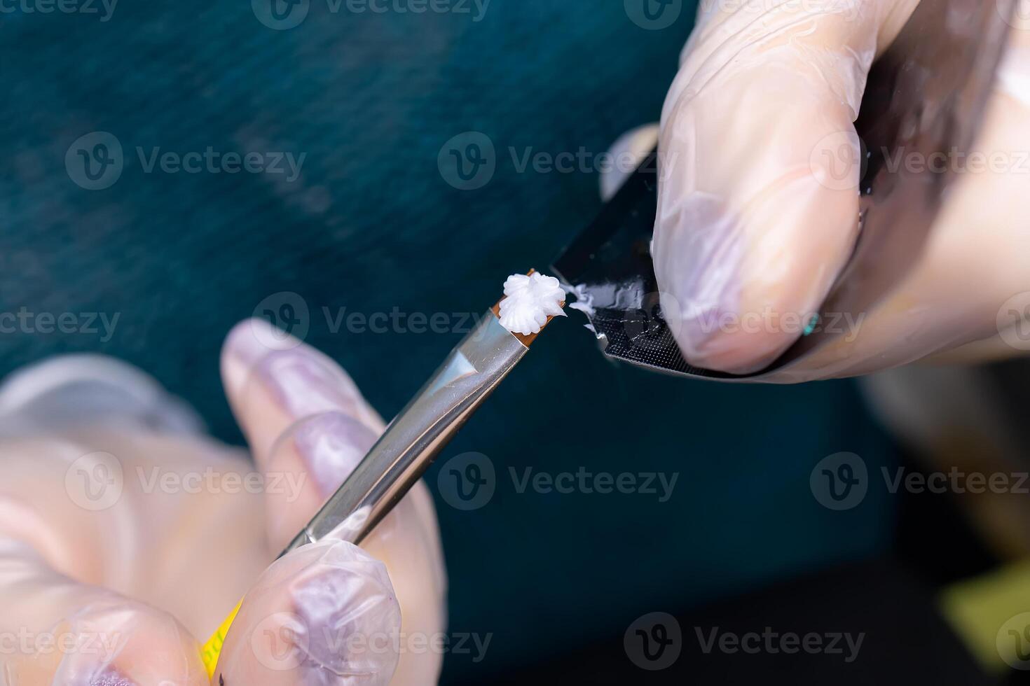 close-up of the master's hands holding a brush and a bag of laminating compounds photo