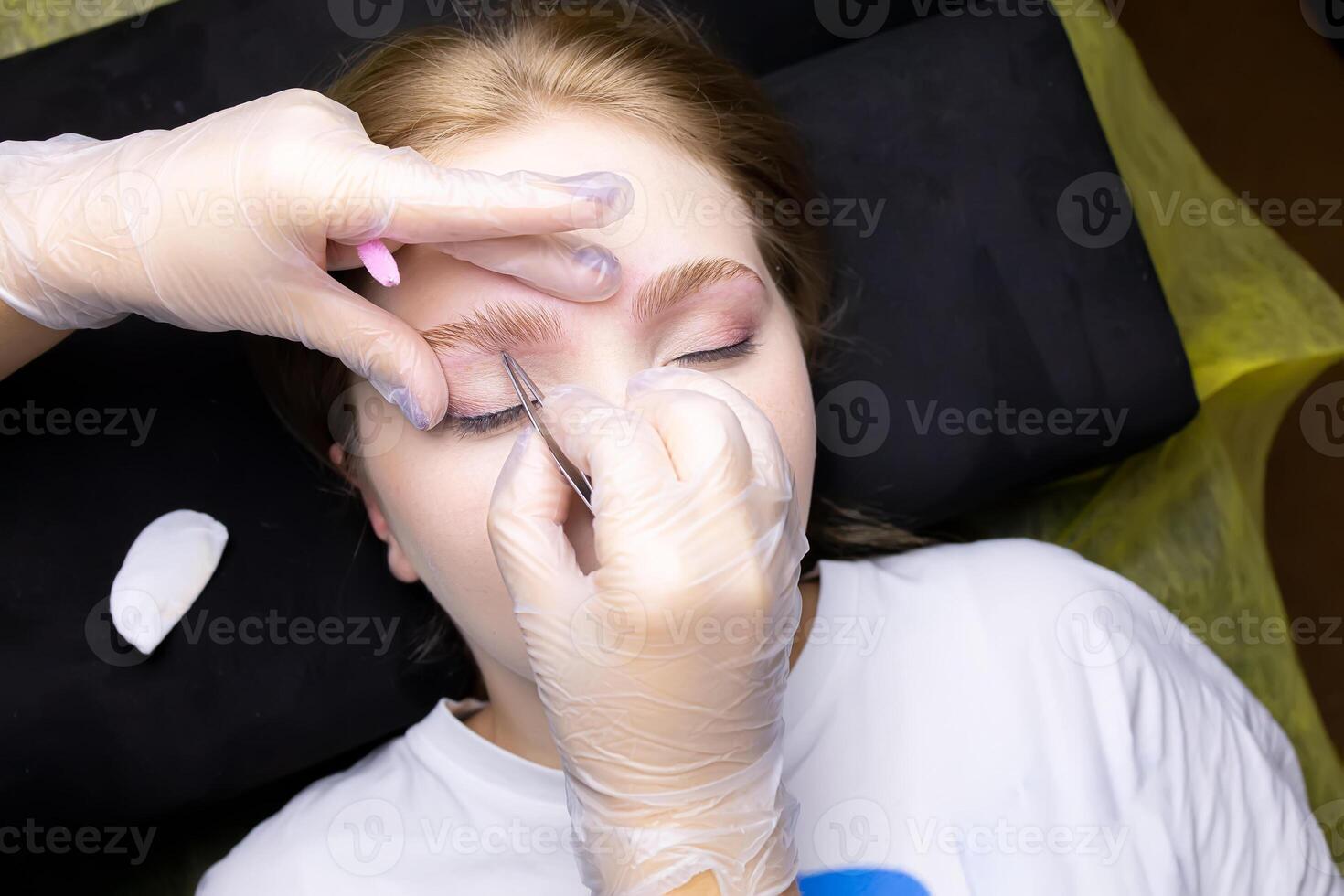 the hands of the master adjust the combed eyebrows up after lamination with compositions photo