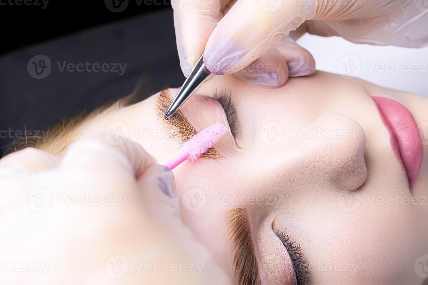 macro photography thinning of eyebrow hairs in the hands of the master there are tweezers and a brush photo