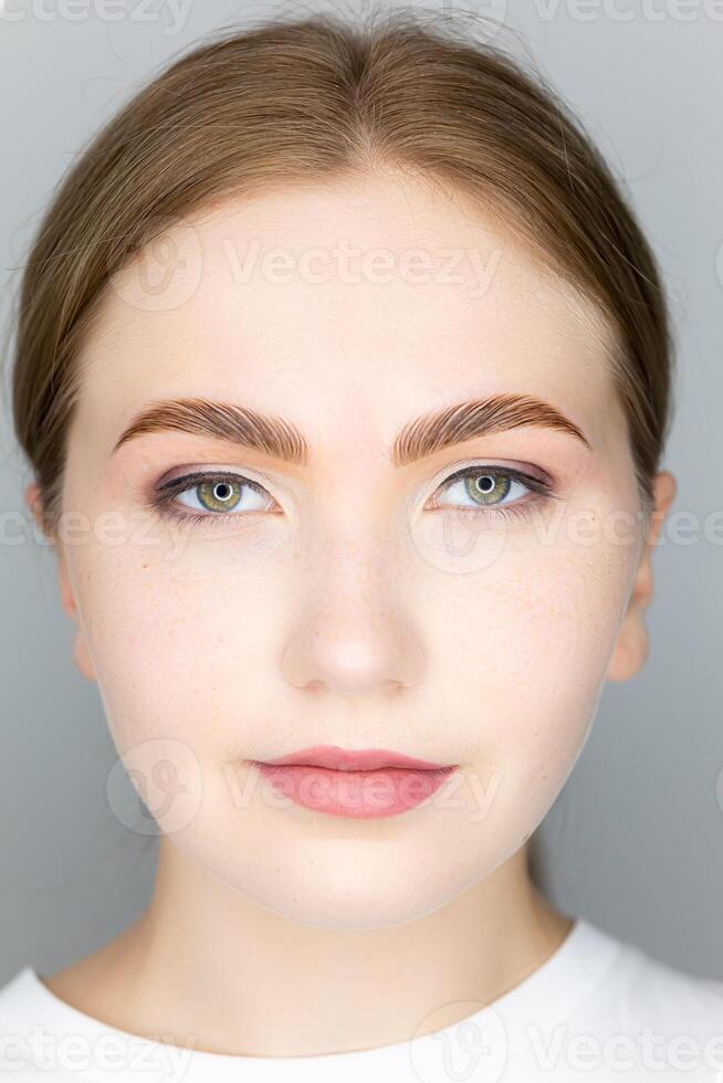 the face of the blonde model and the finished procedure lamination of eyebrows eyebrows combed with the help of long-term styling photo