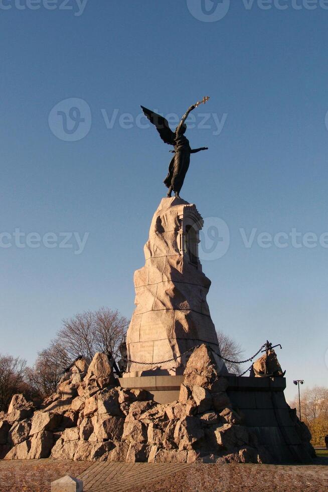 Bronze monument of mermaid with a cross on stone in Kadriorg park in Tallinn, Estonia. Sculpture of Rusalka to the Navy and the dead sailors photo