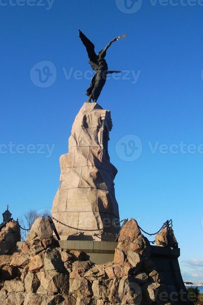 Bronze monument of mermaid with a cross on stone in Kadriorg park in Tallinn, Estonia. Sculpture of Rusalka to the Navy and the dead sailors photo