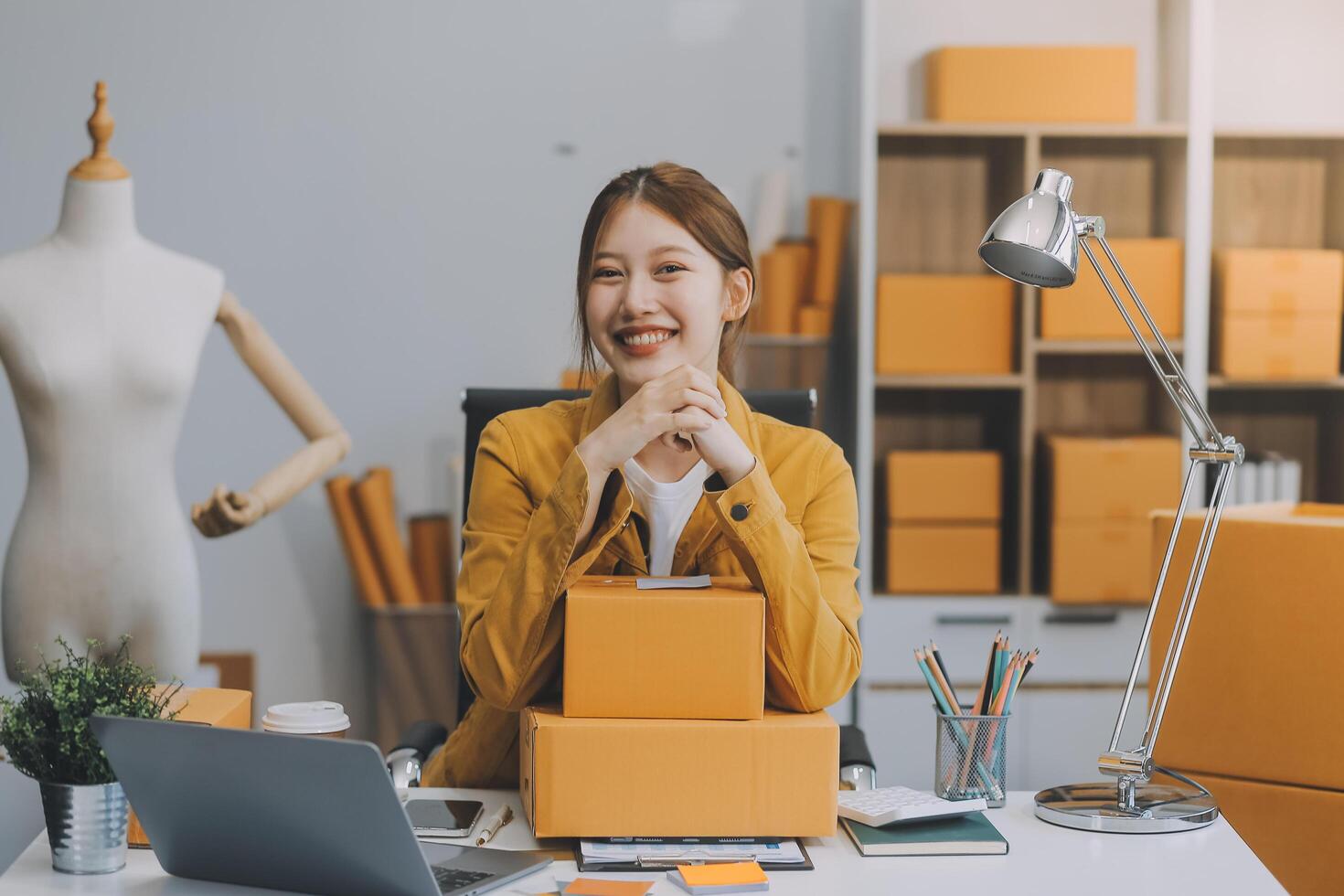 Las pymes asiáticas usan computadoras portátiles para verificar las cajas de envío en línea de pedidos de clientes en casa. Emprendedor de pequeñas empresas pyme freelance. negocio en línea, concepto de trabajo en casa. foto