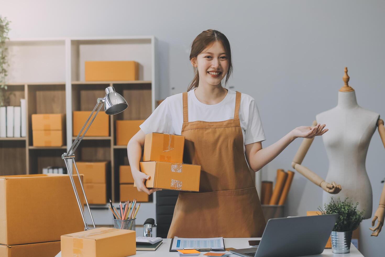 Las pymes asiáticas usan computadoras portátiles para verificar las cajas de envío en línea de pedidos de clientes en casa. Emprendedor de pequeñas empresas pyme freelance. negocio en línea, concepto de trabajo en casa. foto