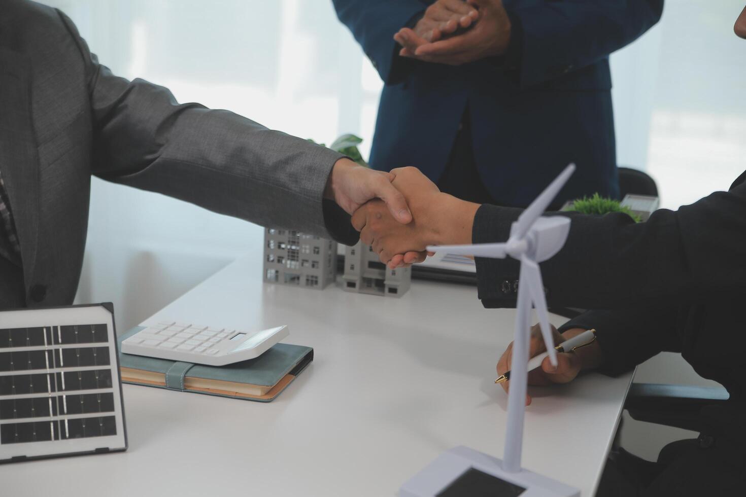 Construction workers holding helmets and vests are shaking hands. real estate concept Architect shaking hands with engineer or builder planning and successful meetings photo