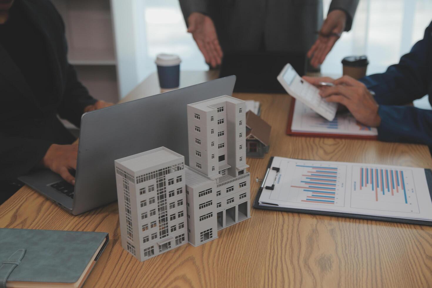 balancing the property sector The real estate agent is explaining the house style to see the house design and the purchase agreement.Wooden house at modern office photo