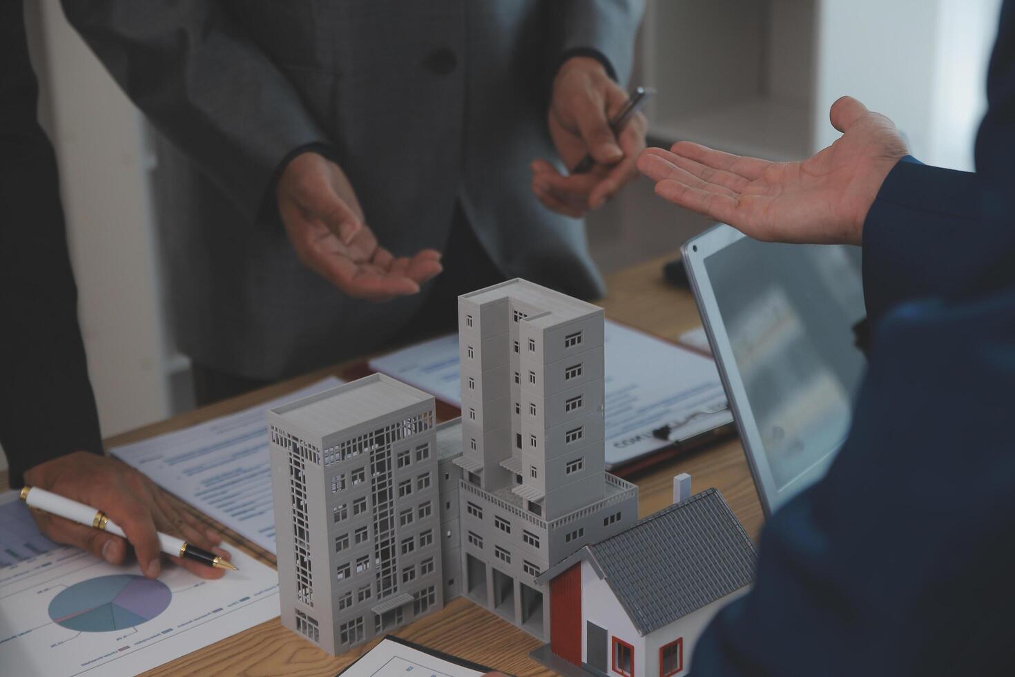 balancing the property sector The real estate agent is explaining the house style to see the house design and the purchase agreement.Wooden house at modern office photo