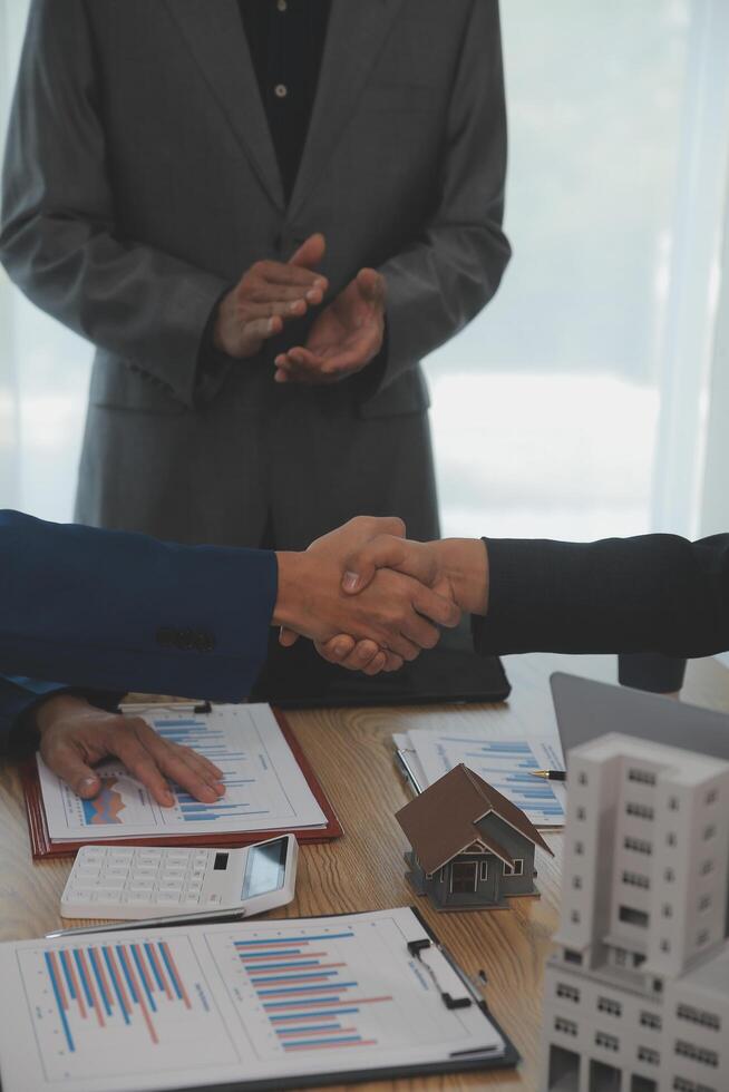 Estate agent shaking hands with customer after contract signature photo