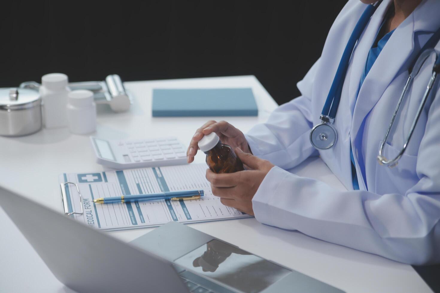 Cropped view of doctor in white coat holding bottle medication, prescribing pills to sick patient via online consultation. Family therapist recommend quality medicines. Healthcare, treatment concept photo