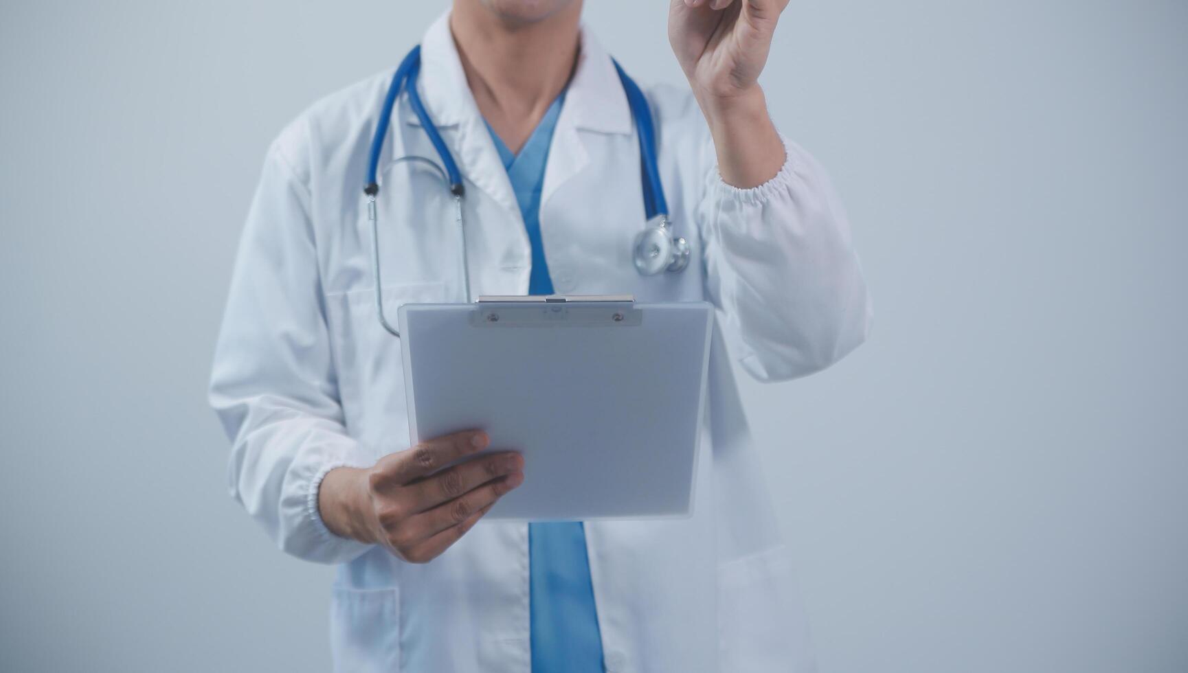 Mature male doctor with tablet pc is giving presentation. Blurred background indoors. photo