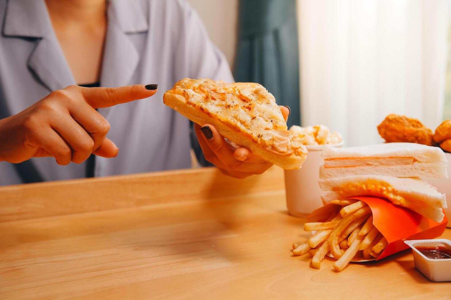 Cropped image of woman holding pizza slice at restaurant photo