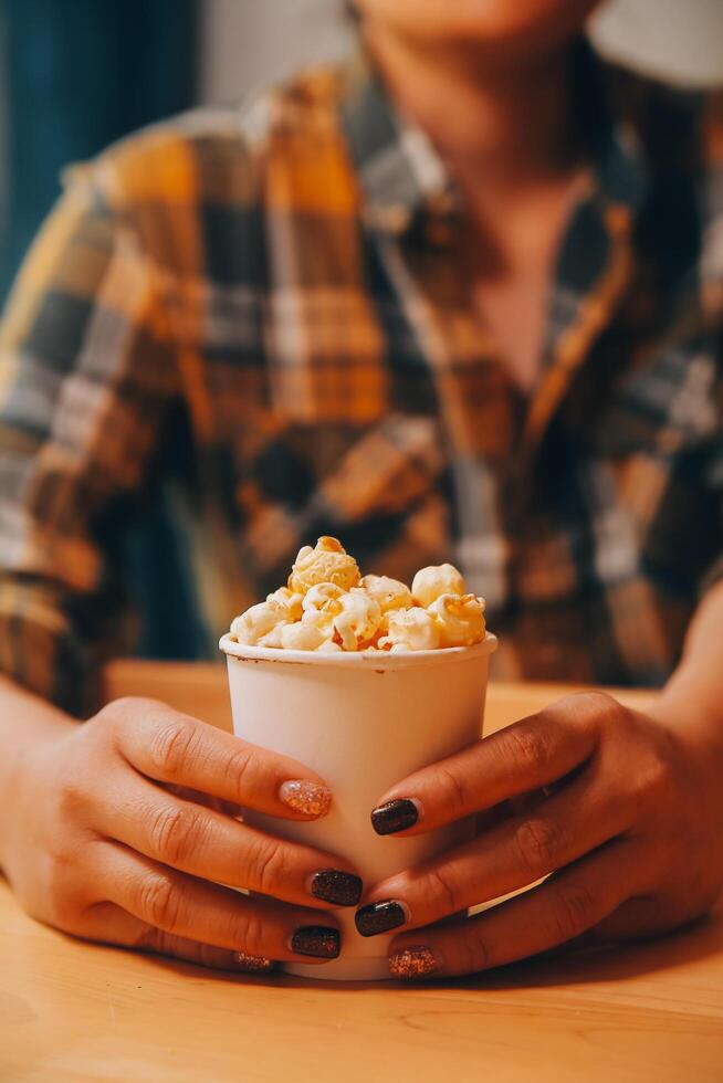 un mujer participación un cuenco de palomitas de maiz foto