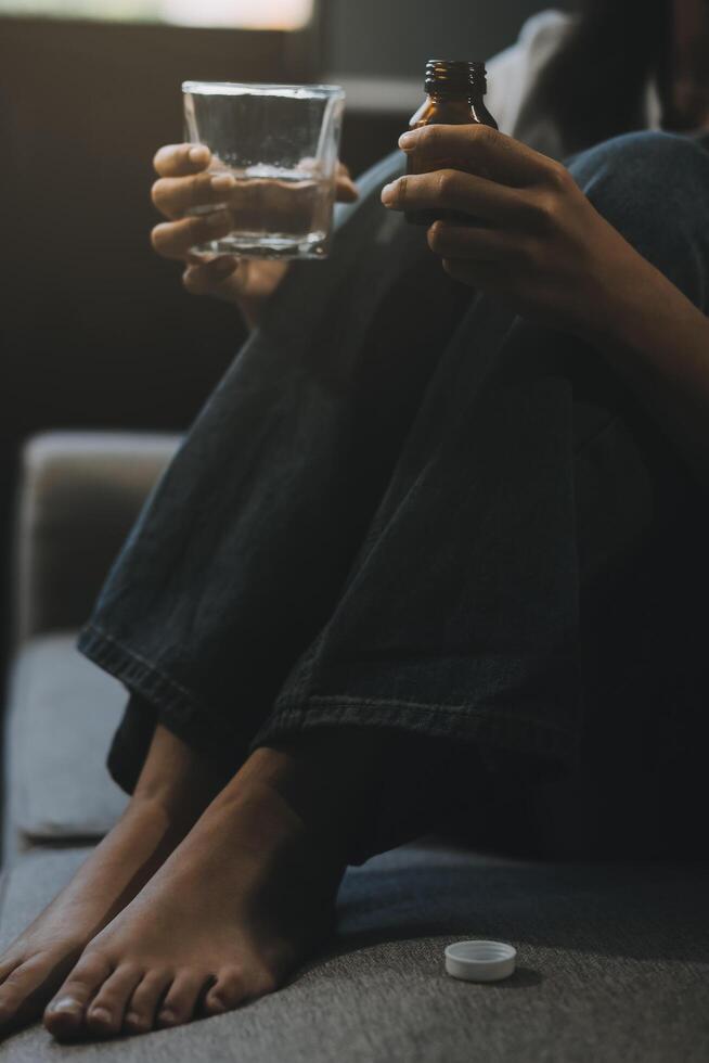 Upset woman frustrated by problem with work or relationships, sitting on couch, embracing knees, covered face in hand, feeling despair and anxiety, loneliness, having psychological trouble photo