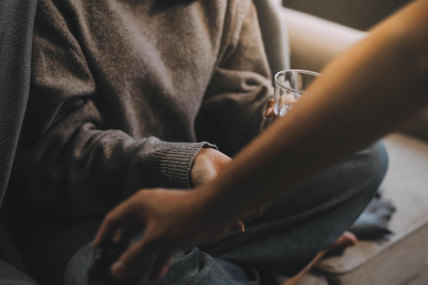 Upset woman frustrated by problem with work or relationships, sitting on couch, embracing knees, covered face in hand, feeling despair and anxiety, loneliness, having psychological trouble photo