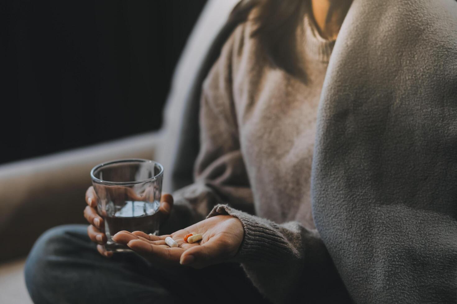 Upset woman frustrated by problem with work or relationships, sitting on couch, embracing knees, covered face in hand, feeling despair and anxiety, loneliness, having psychological trouble photo