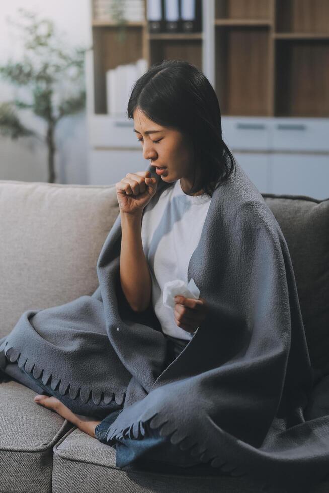 Upset woman frustrated by problem with work or relationships, sitting on couch, embracing knees, covered face in hand, feeling despair and anxiety, loneliness, having psychological trouble photo