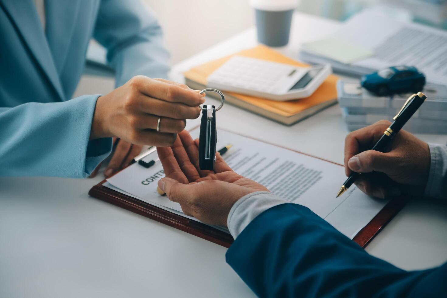 Insurance officers hand over the car keys after the tenant. have signed an auto insurance document or a lease or agreement document Buying or selling a new or used car with a car photo