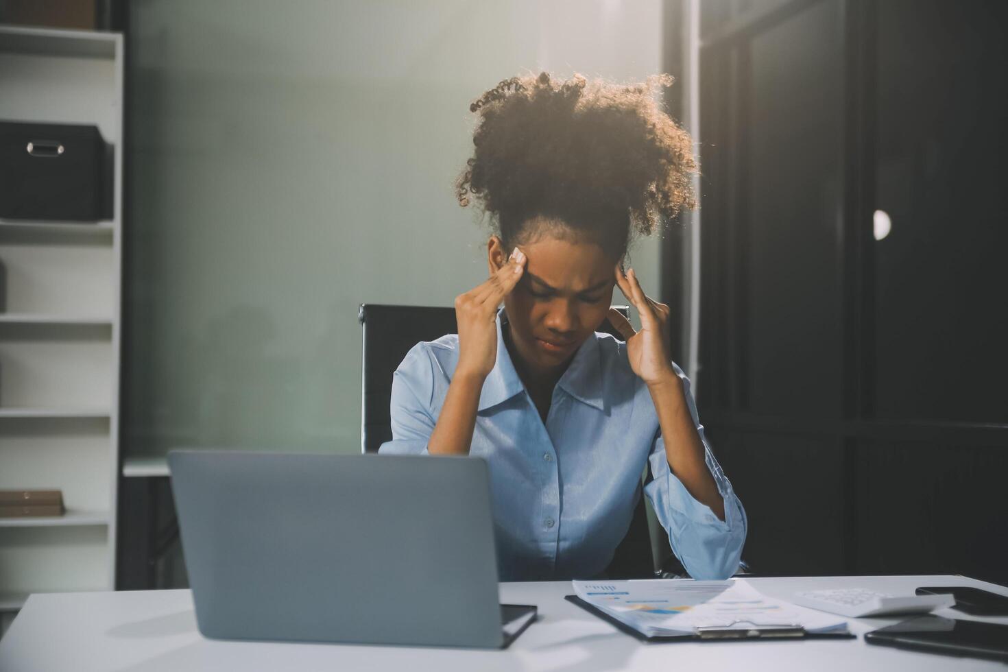 business woman sitting at work stressed , out working hard Feeling stressed out and dizzy from your job photo