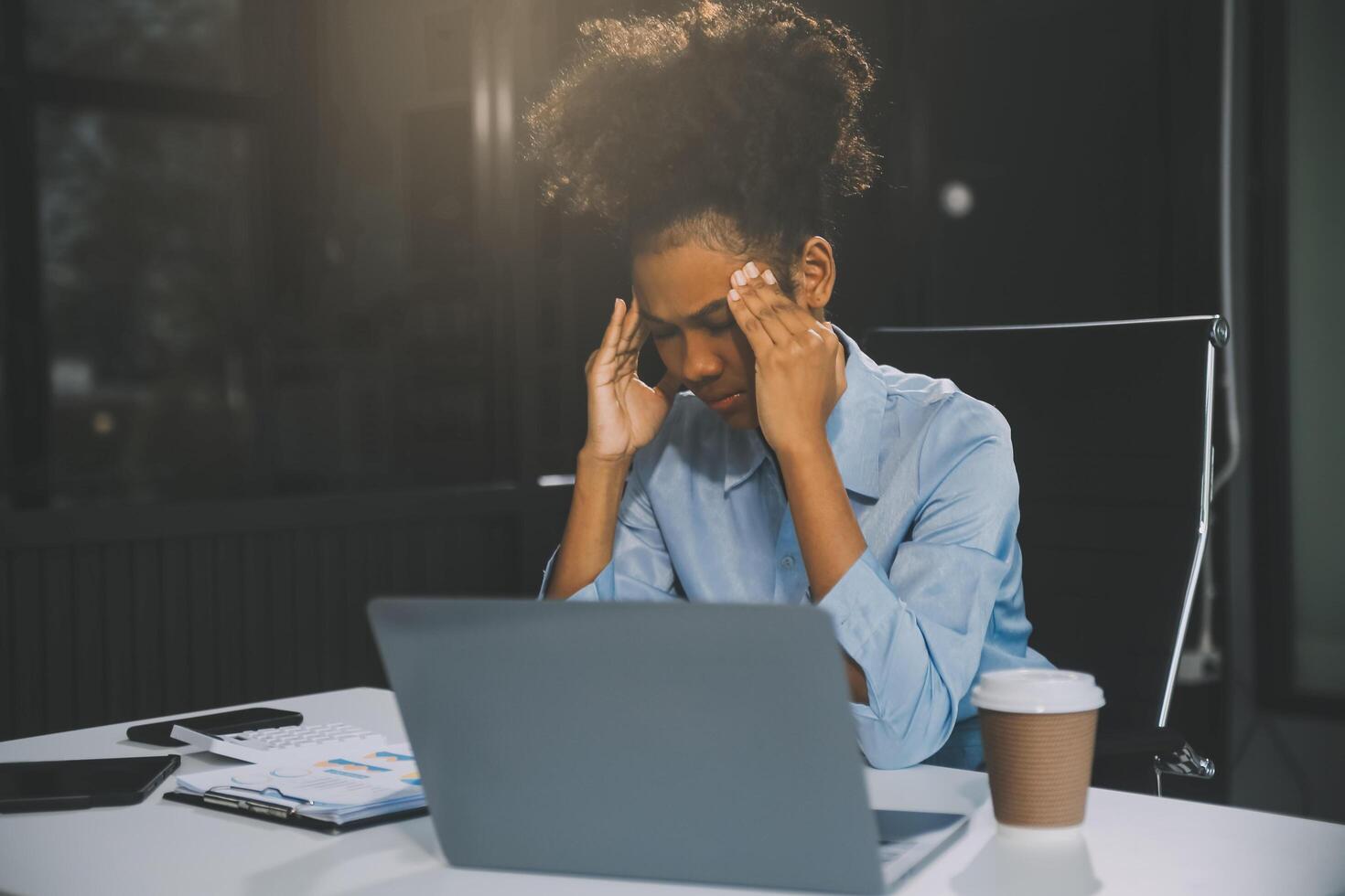 business woman sitting at work stressed , out working hard Feeling stressed out and dizzy from your job photo