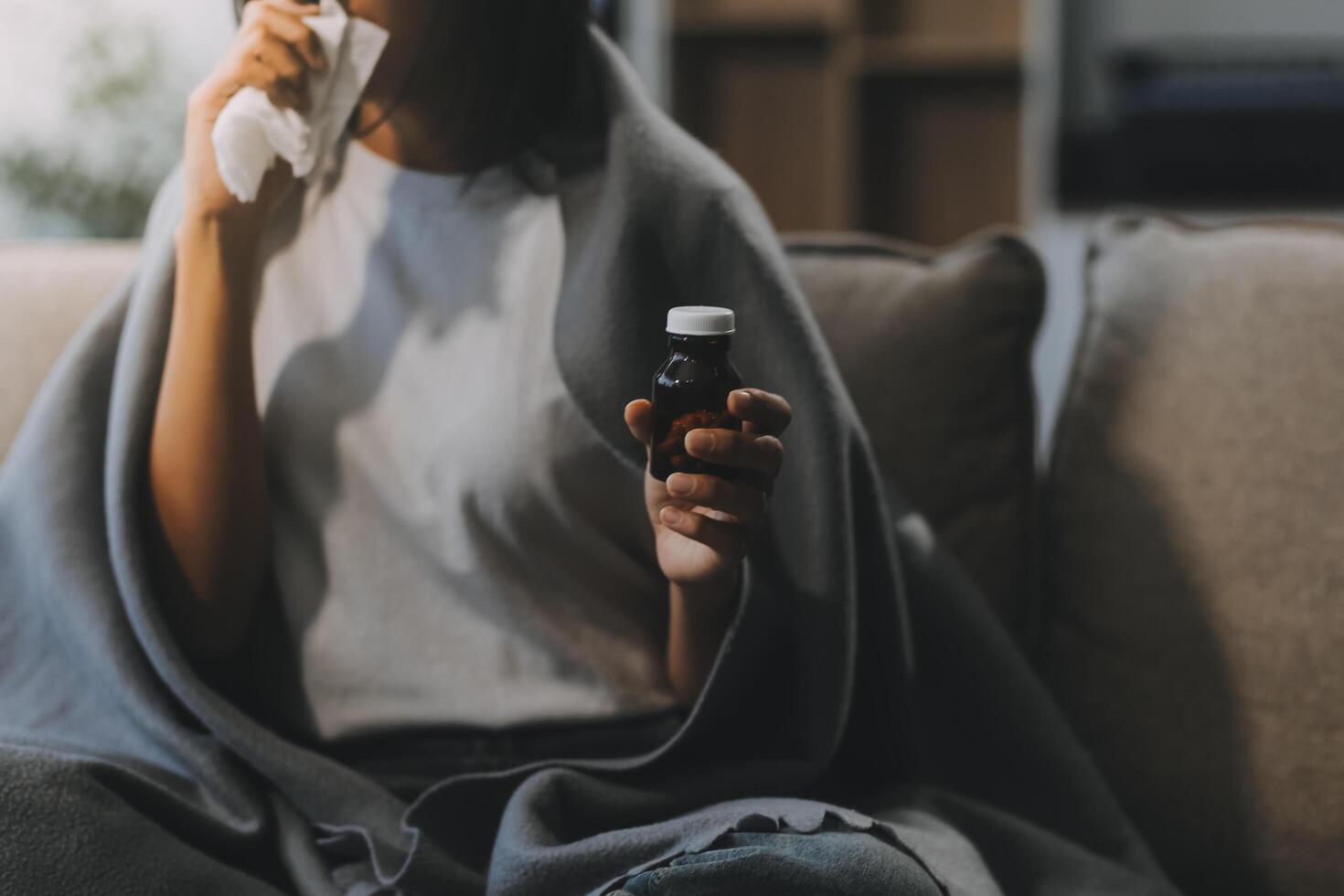 Upset woman frustrated by problem with work or relationships, sitting on couch, embracing knees, covered face in hand, feeling despair and anxiety, loneliness, having psychological trouble photo