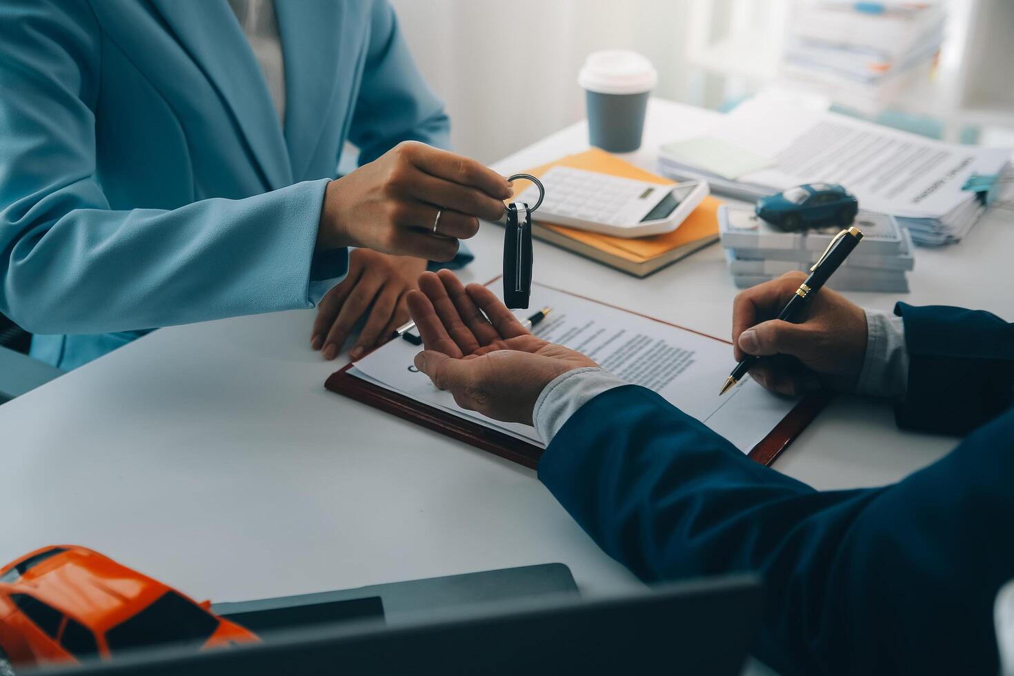 Insurance officers hand over the car keys after the tenant. have signed an auto insurance document or a lease or agreement document Buying or selling a new or used car with a car photo