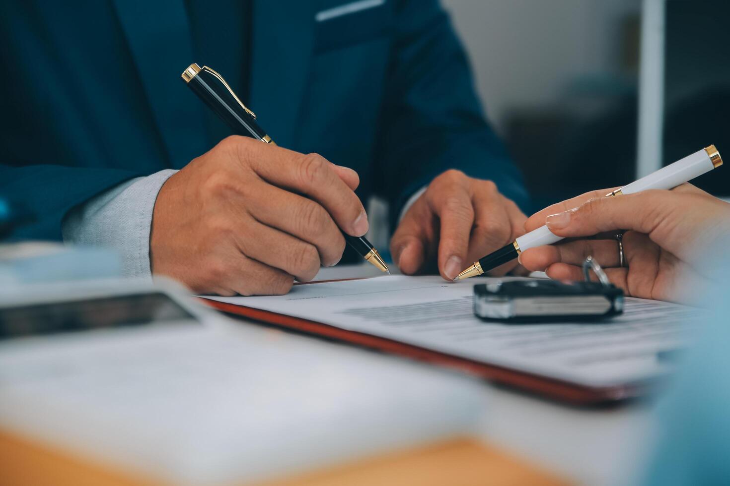 Insurance officers hand over the car keys after the tenant. have signed an auto insurance document or a lease or agreement document Buying or selling a new or used car with a car photo