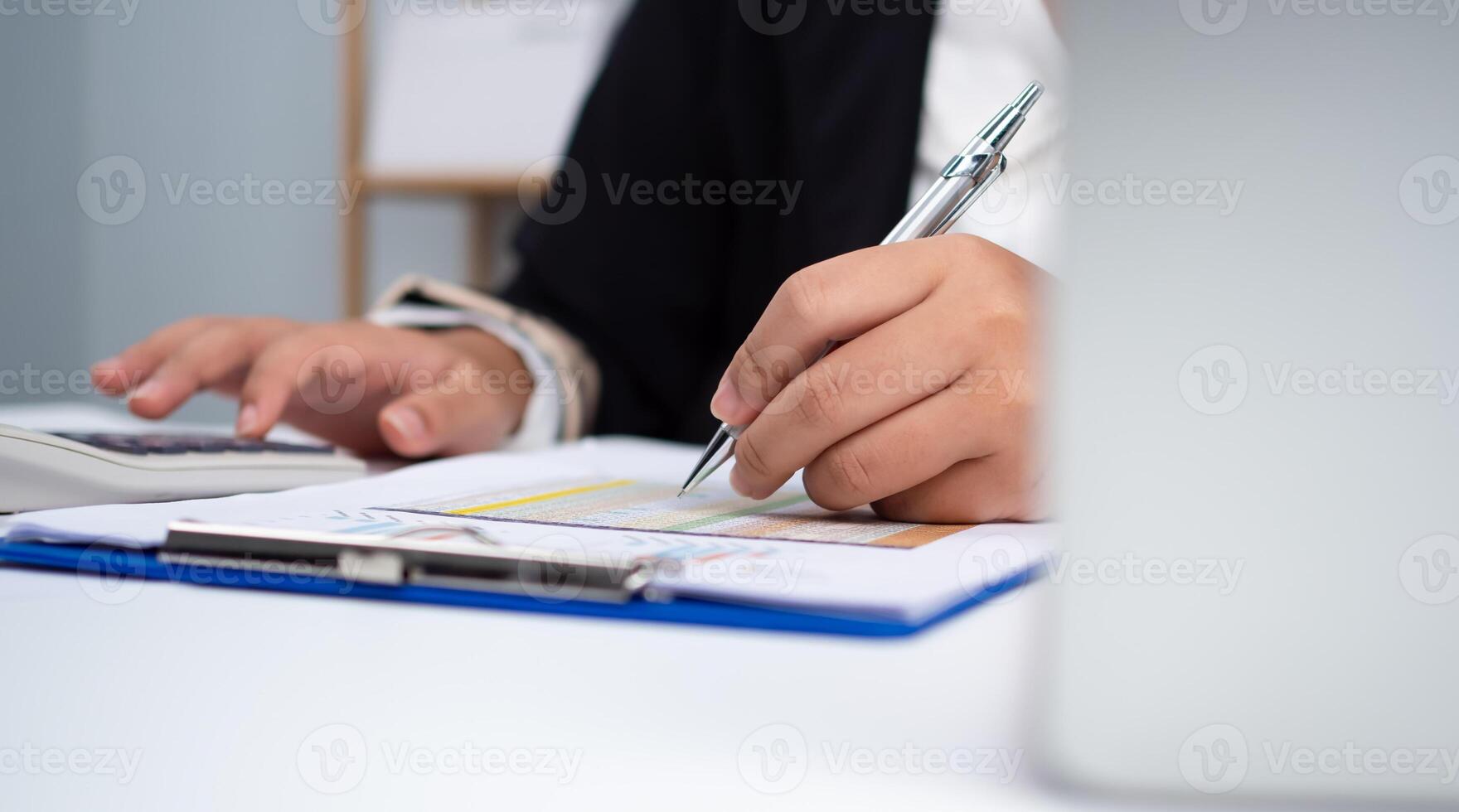 Photo close up hands of business woman working on desk office with using a calculator to calculate the numbers, Finance accounting concept, Accounting checking company budget accounting documents.