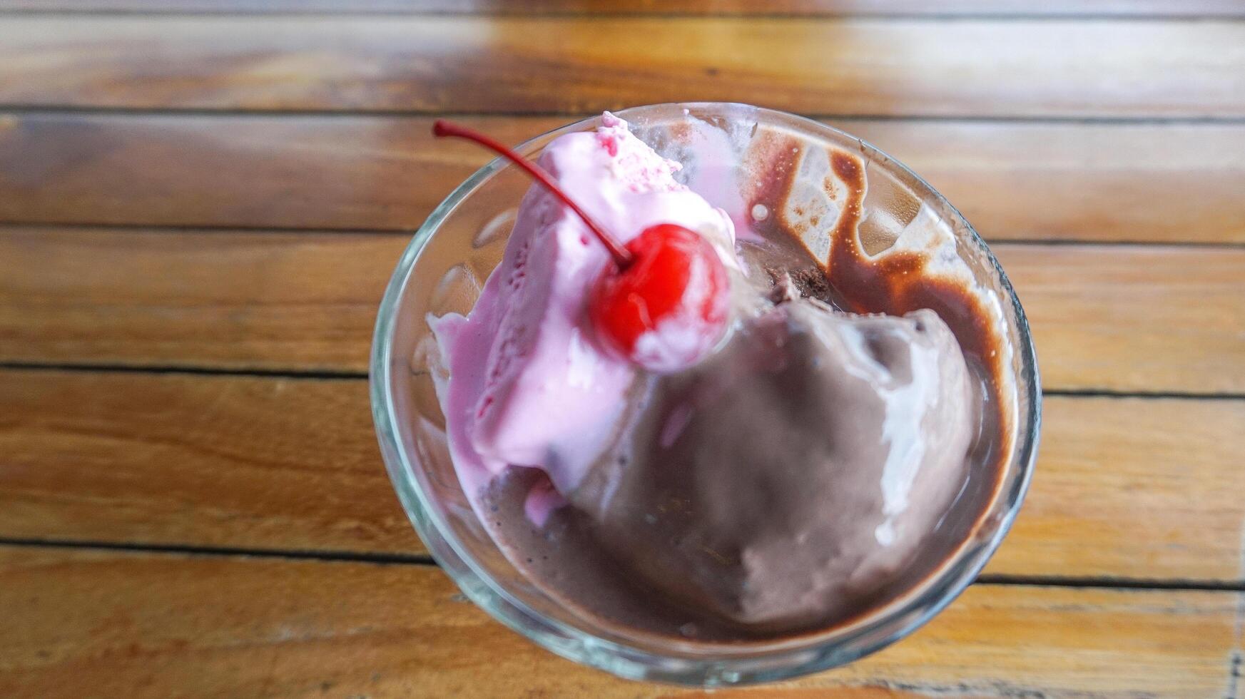 Chocolate and strawberry flavored ice cream with cherry on top photo