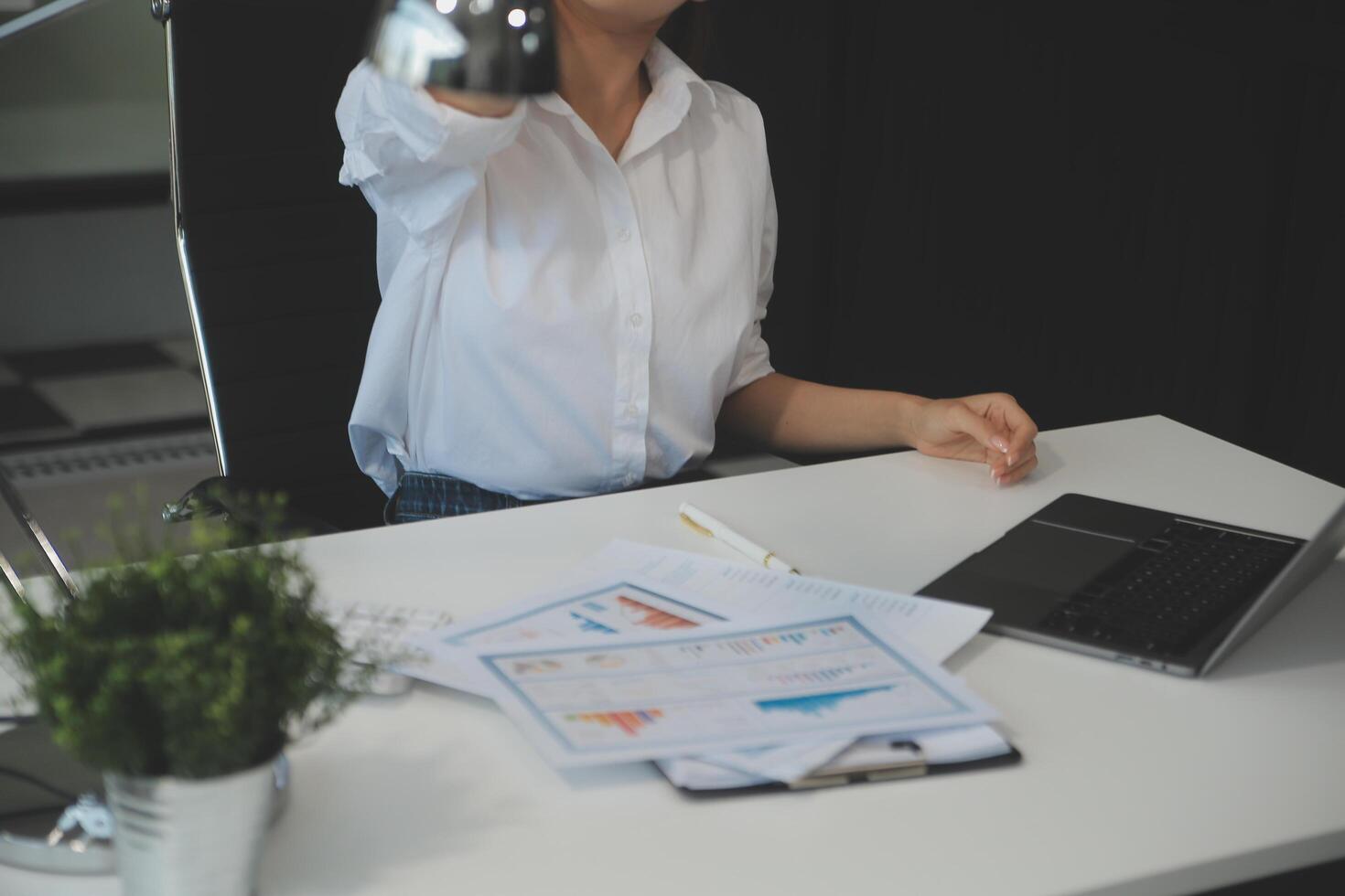 Young Asian woman feeling migraine head strain. Tired, Overworked businesswoman financier while working on laptop computer in office. photo