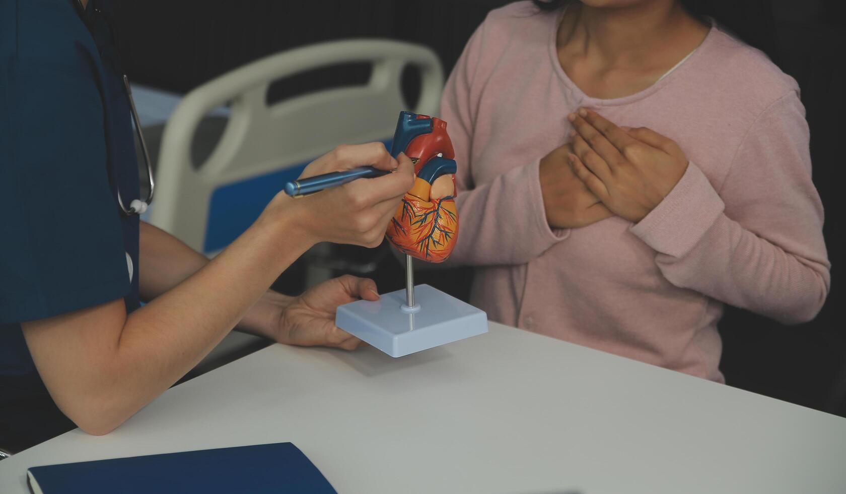 médico demostración interno órganos en 3d humano modelo. mujer con estetoscopio en laboratorio Saco sentado a mesa con ordenador portátil y hablando acerca de personas anatomía. salud cuidado y médico educación concepto. foto