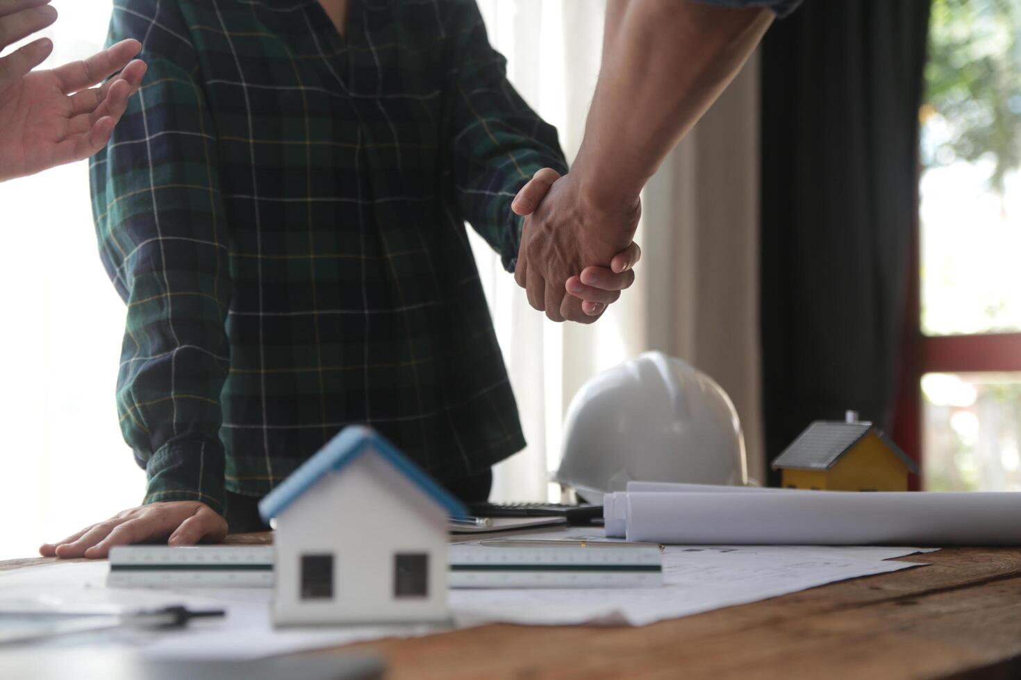 Engineer and contractor join hands after signing contract,They are having a modern building project together. successful cooperation team concept photo