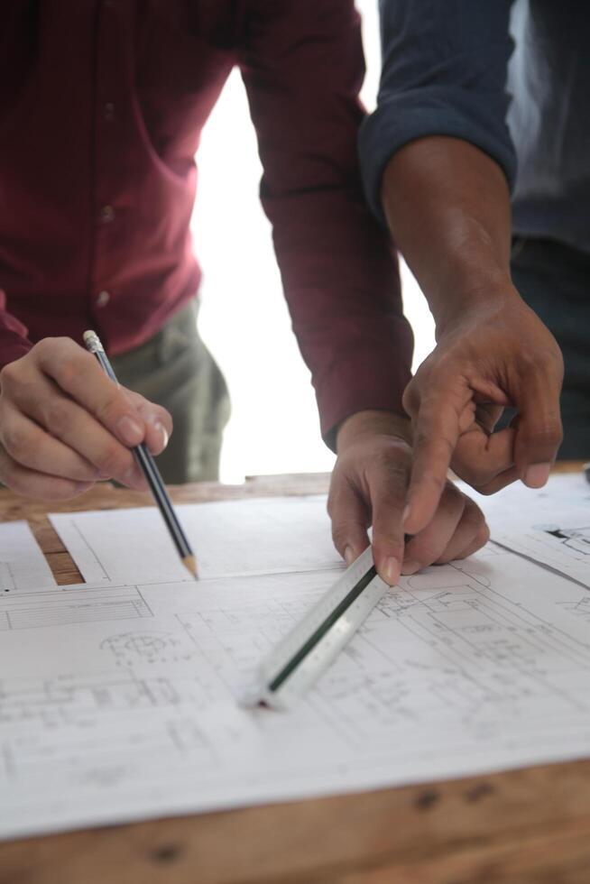 concepto de construcción y estructura de reunión de ingenieros o arquitectos para el proyecto que trabaja con socios y herramientas de ingeniería en la construcción de modelos y planos en el lugar de trabajo, contrato para ambas empresas. foto