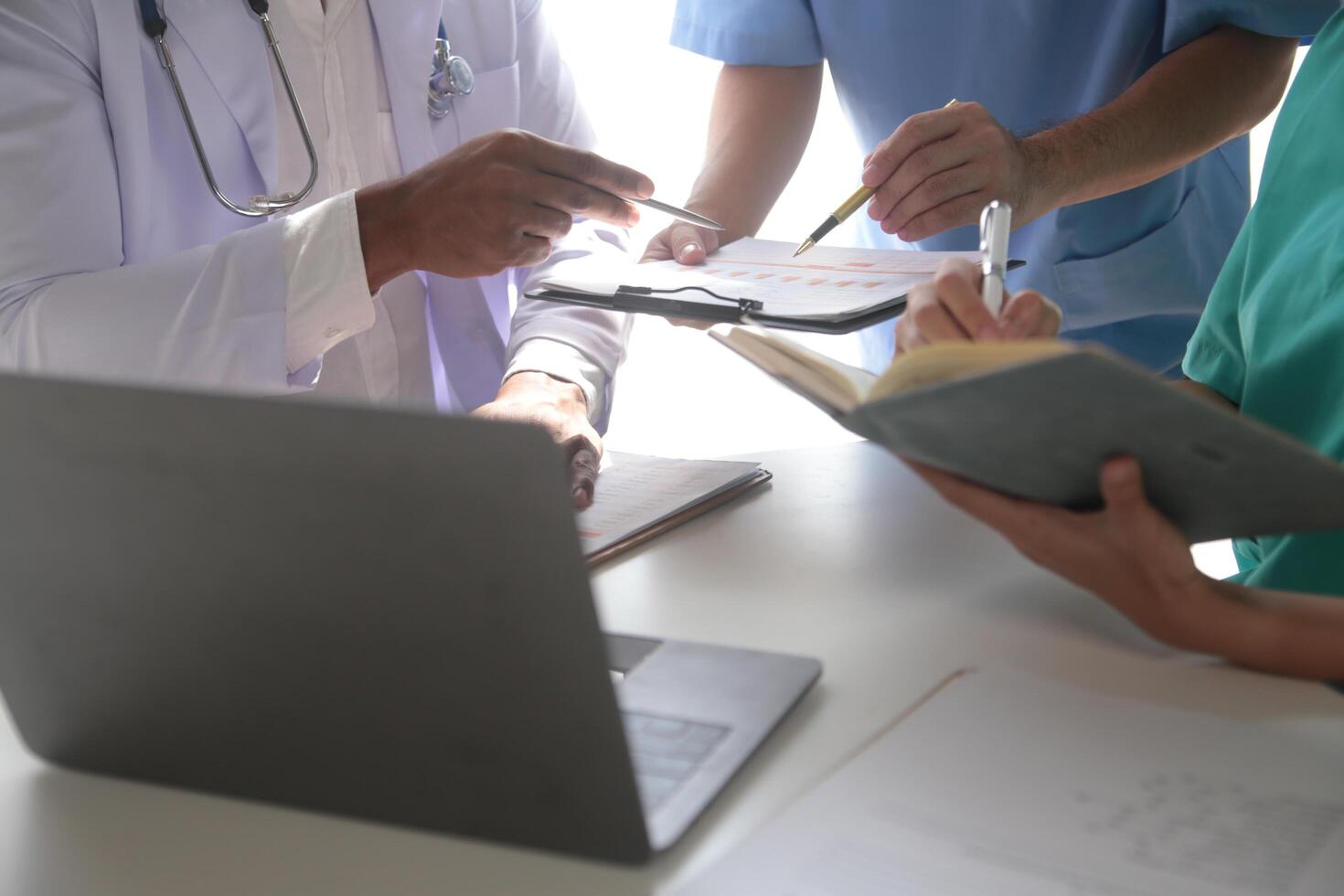 médico equipo reunión alrededor mesa en moderno hospital foto